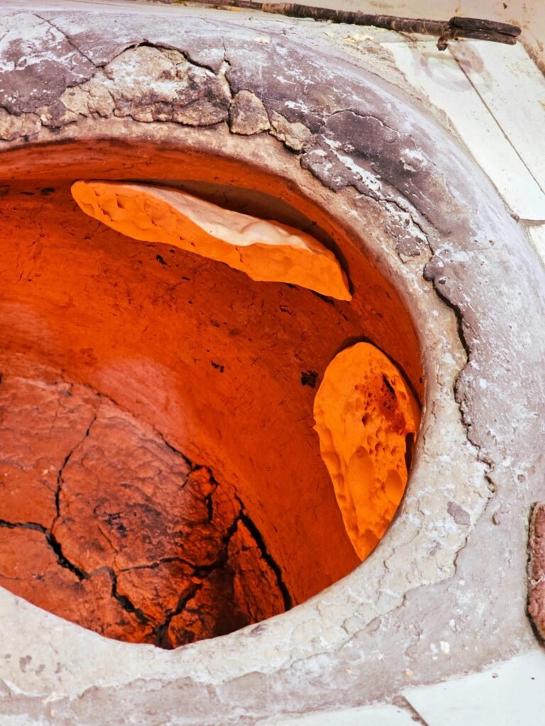 Close-up of a traditional Iranian tandoor oven baking flatbread in Qeshm, Iran.